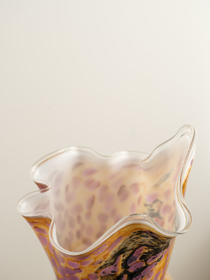 Handblown art glass vase with flowing petal form in shades of lilac, amber, and black.