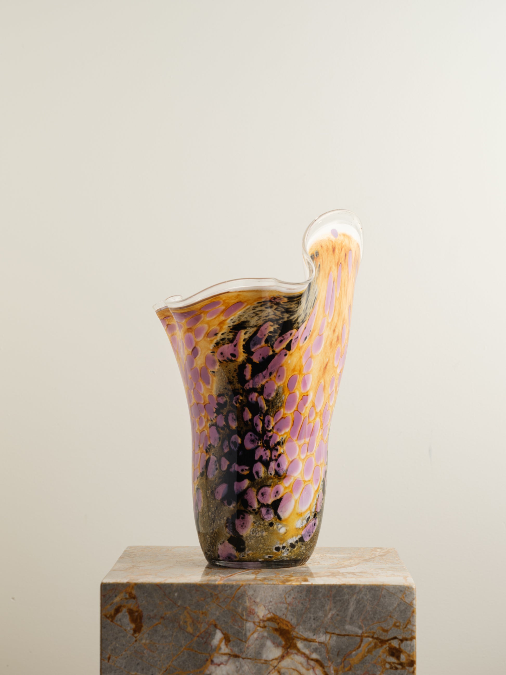 Handblown art glass vase with flowing petal form in shades of lilac, amber, and black.