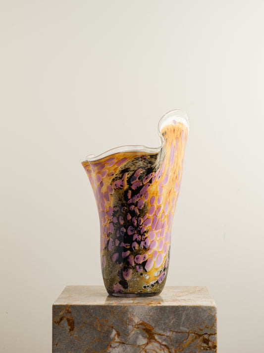 Handblown art glass vase with flowing petal form in shades of lilac, amber, and black.