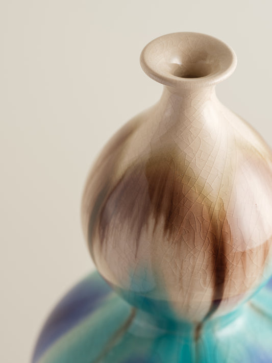 Double-gourd ceramic vase with flowing blue, teal, and beige glaze reminiscent of ocean tides.