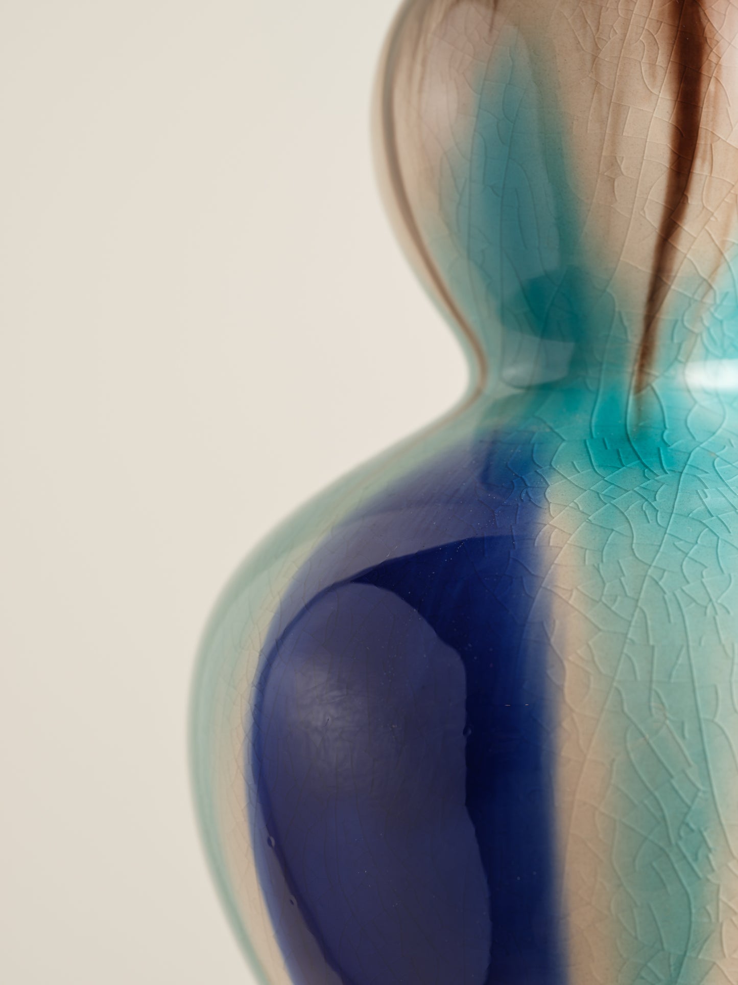 Double-gourd ceramic vase with flowing blue, teal, and beige glaze reminiscent of ocean tides.