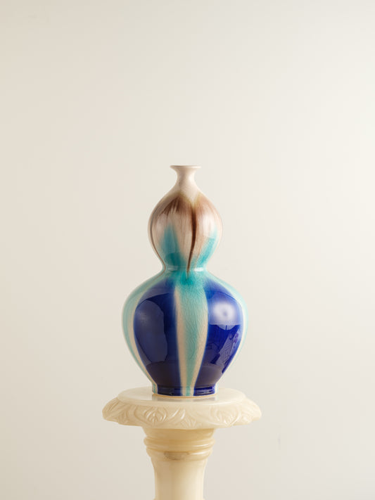 Double-gourd ceramic vase with flowing blue, teal, and beige glaze reminiscent of ocean tides.