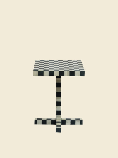 Modern black and white checkerboard side table with square top and pedestal base