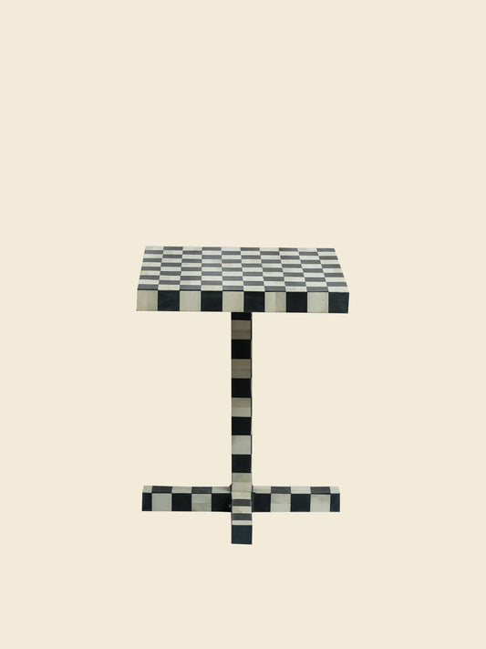 Modern black and white checkerboard side table with square top and pedestal base