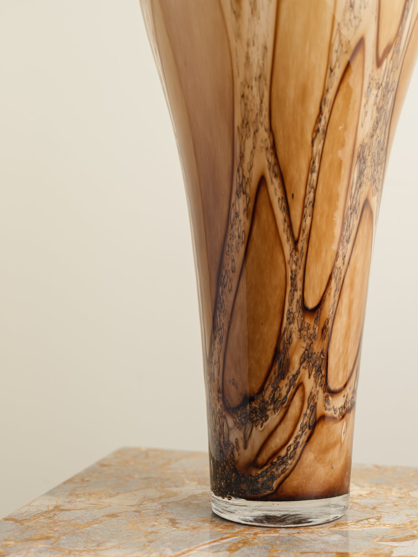 Tall fluted glass vase with caramel and brown marbled driftwood pattern.