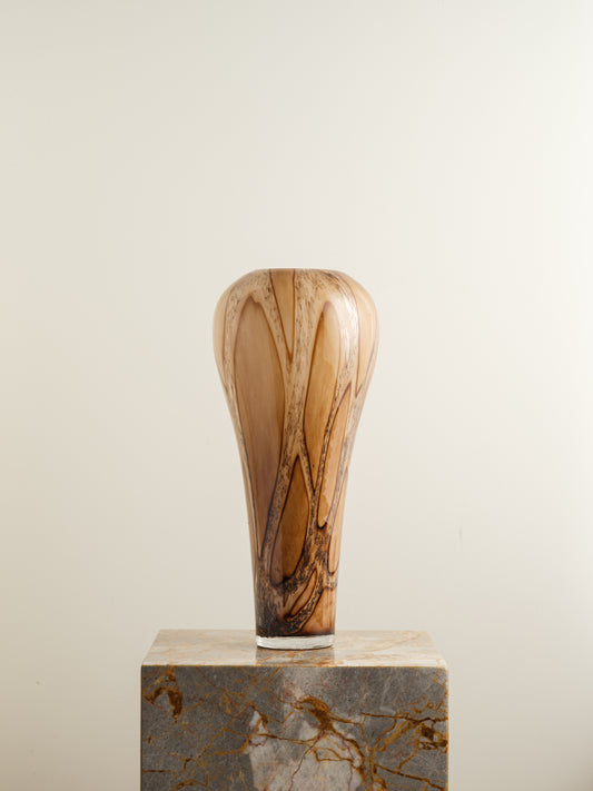 Tall fluted glass vase with caramel and brown marbled driftwood pattern.
