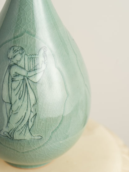 Song Whisper Celadon Vase, a delicate ceramic vessel with a slender flared neck and subtle engraved figure motif on a pale green glaze.