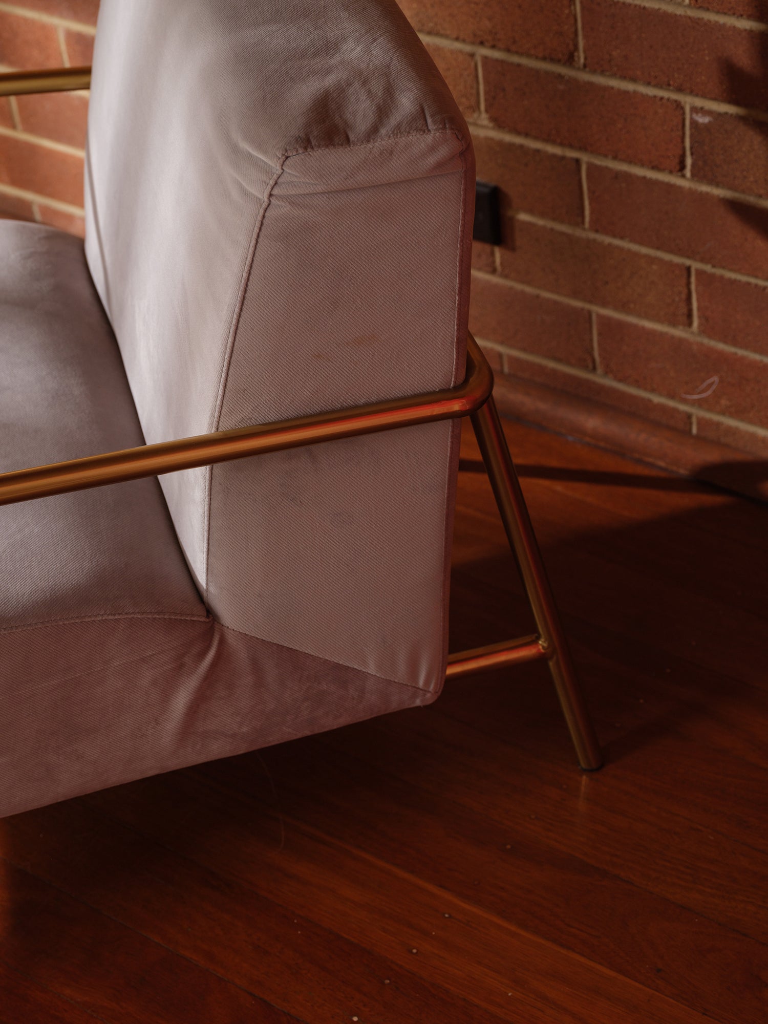Contemporary lounge accent chair with soft grey upholstery and gold metal frame