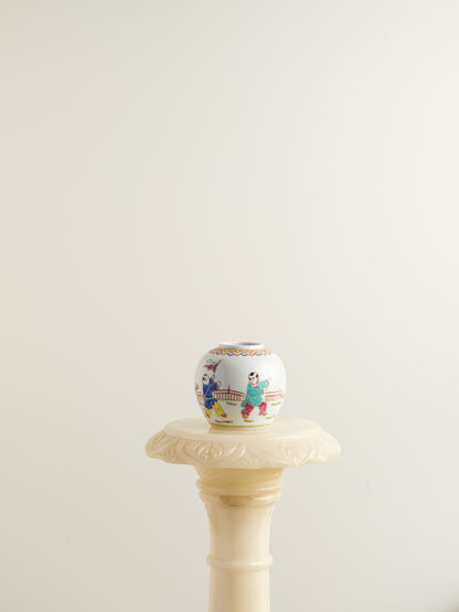 Small porcelain jar hand-painted with playful courtyard children in bright traditional robes.