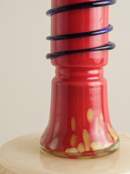 Red glass bud vase with flared rim and cobalt spiral accent wrapping around the neck.
