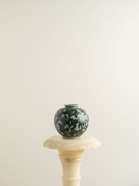 Hand-painted ceramic jar in deep green tones with scrolling leaf and floral patterns.