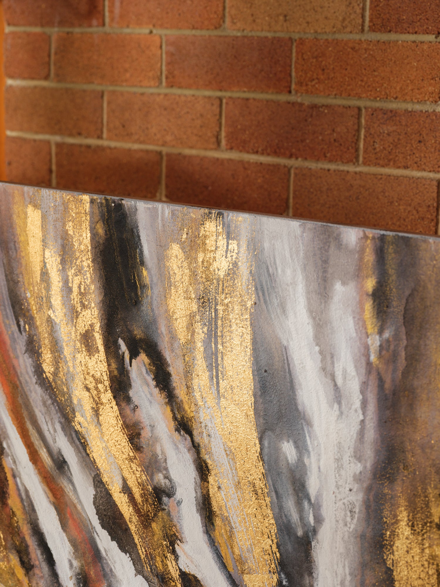 Abstract acrylic painting titled Ember Current, featuring dynamic swirls of gold, black, white, and fiery orange tones.