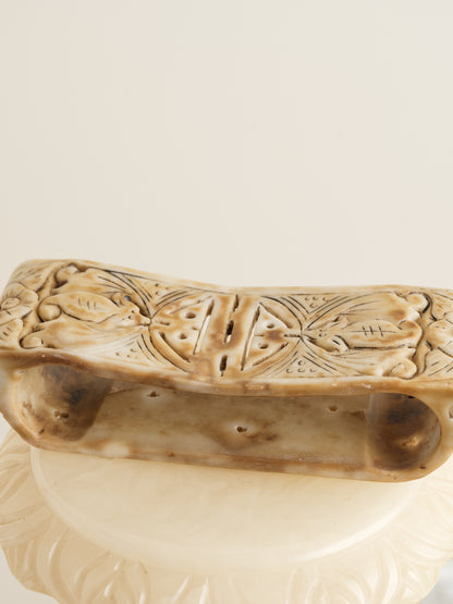 Ivory-toned pedestal stand with curved top and carved detailing, ideal for displaying vases or sculptures.