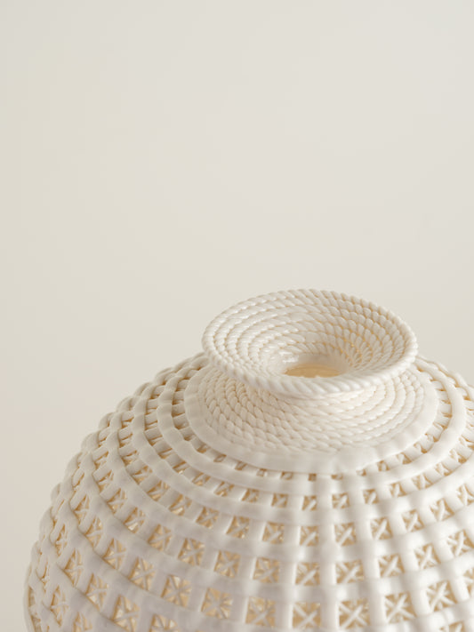 White porcelain meiping vase with openwork lattice pattern and flared rim.