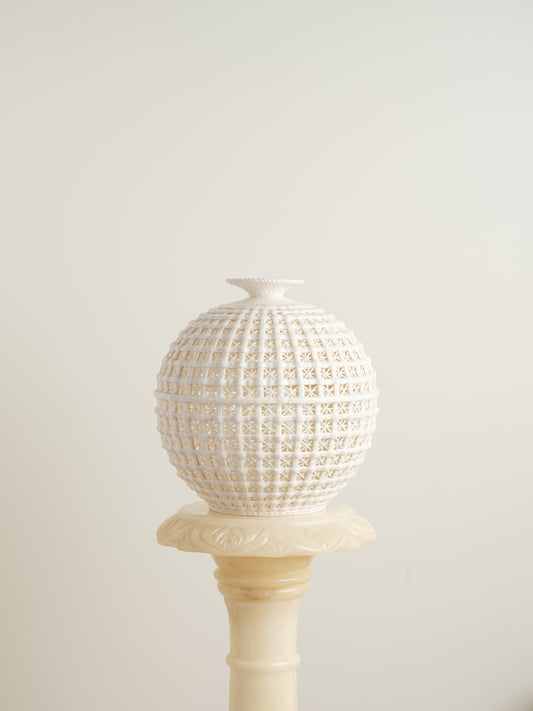 White porcelain meiping vase with openwork lattice pattern and flared rim.