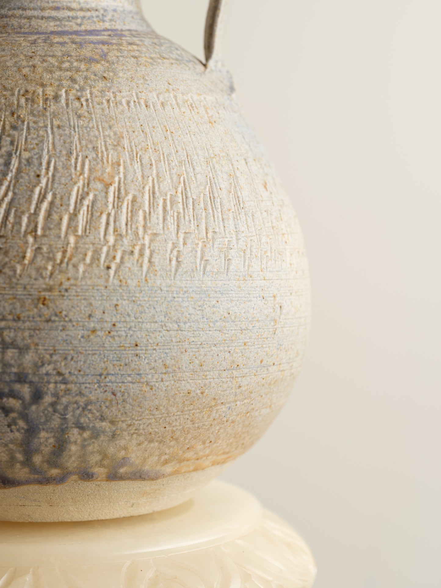 Hand-thrown stoneware ewer with lavender and sand-toned glaze and textured surface.