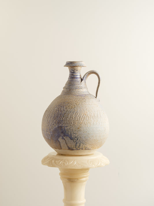 Hand-thrown stoneware ewer with lavender and sand-toned glaze and textured surface.