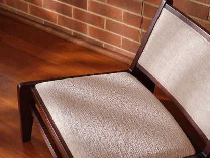 Low armchair with dark brown wooden frame and beige fabric upholstery, modern vintage design