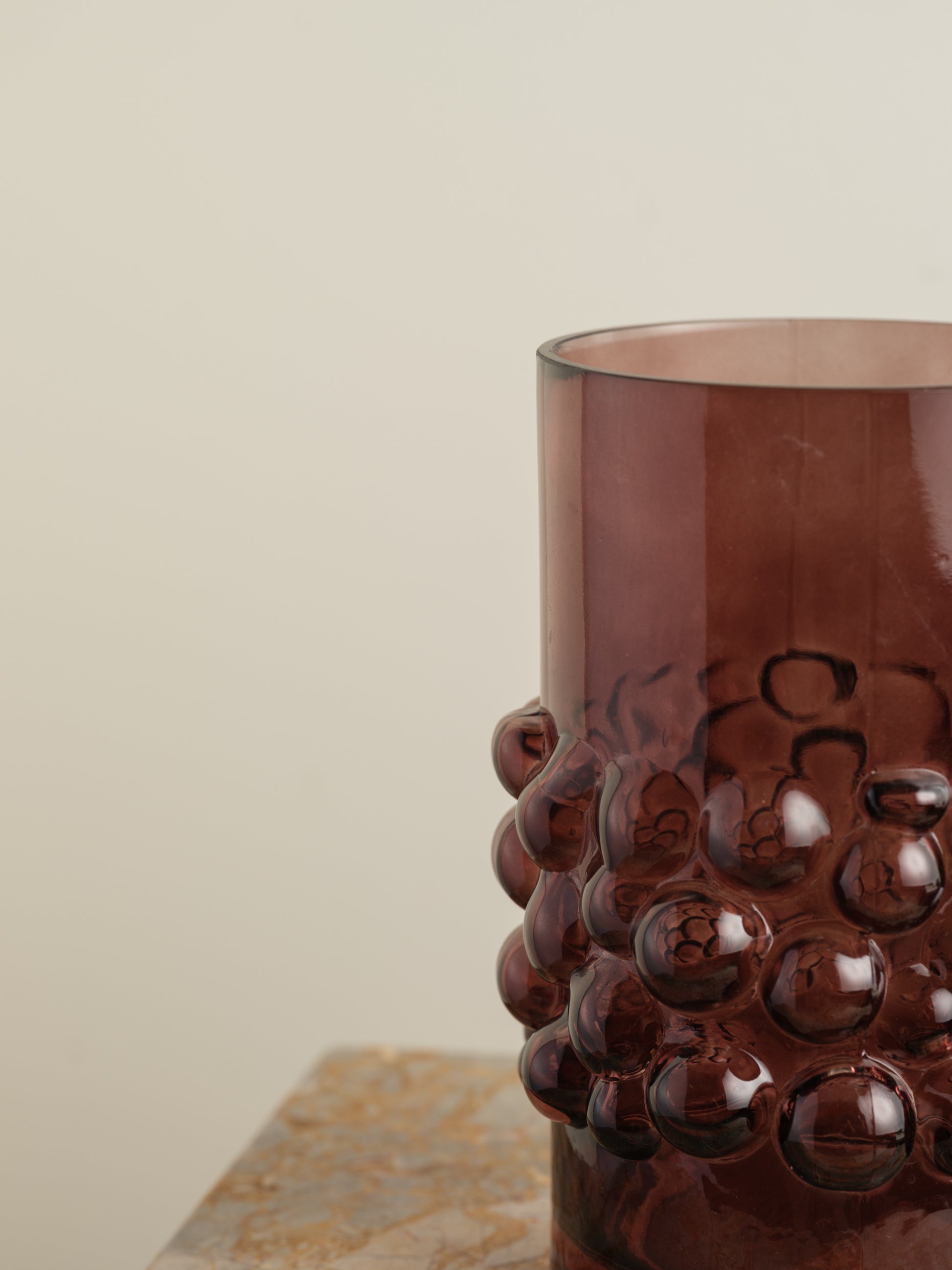 Deep plum-coloured glass vase with cylindrical form and raised hobnail texture around the middle.