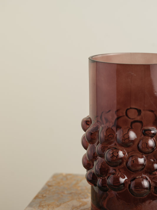 Deep plum-coloured glass vase with cylindrical form and raised hobnail texture around the middle.