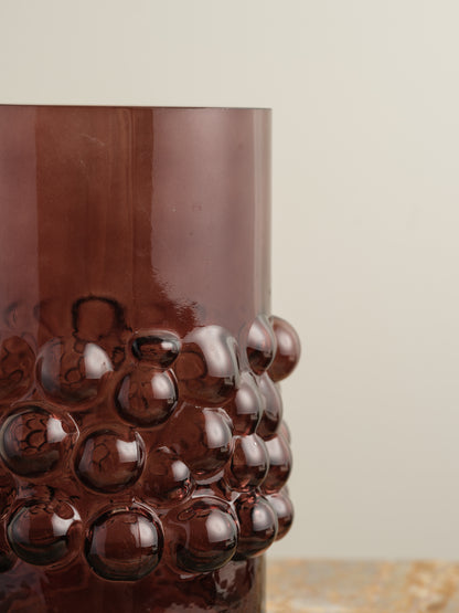 Deep plum-coloured glass vase with cylindrical form and raised hobnail texture around the middle.
