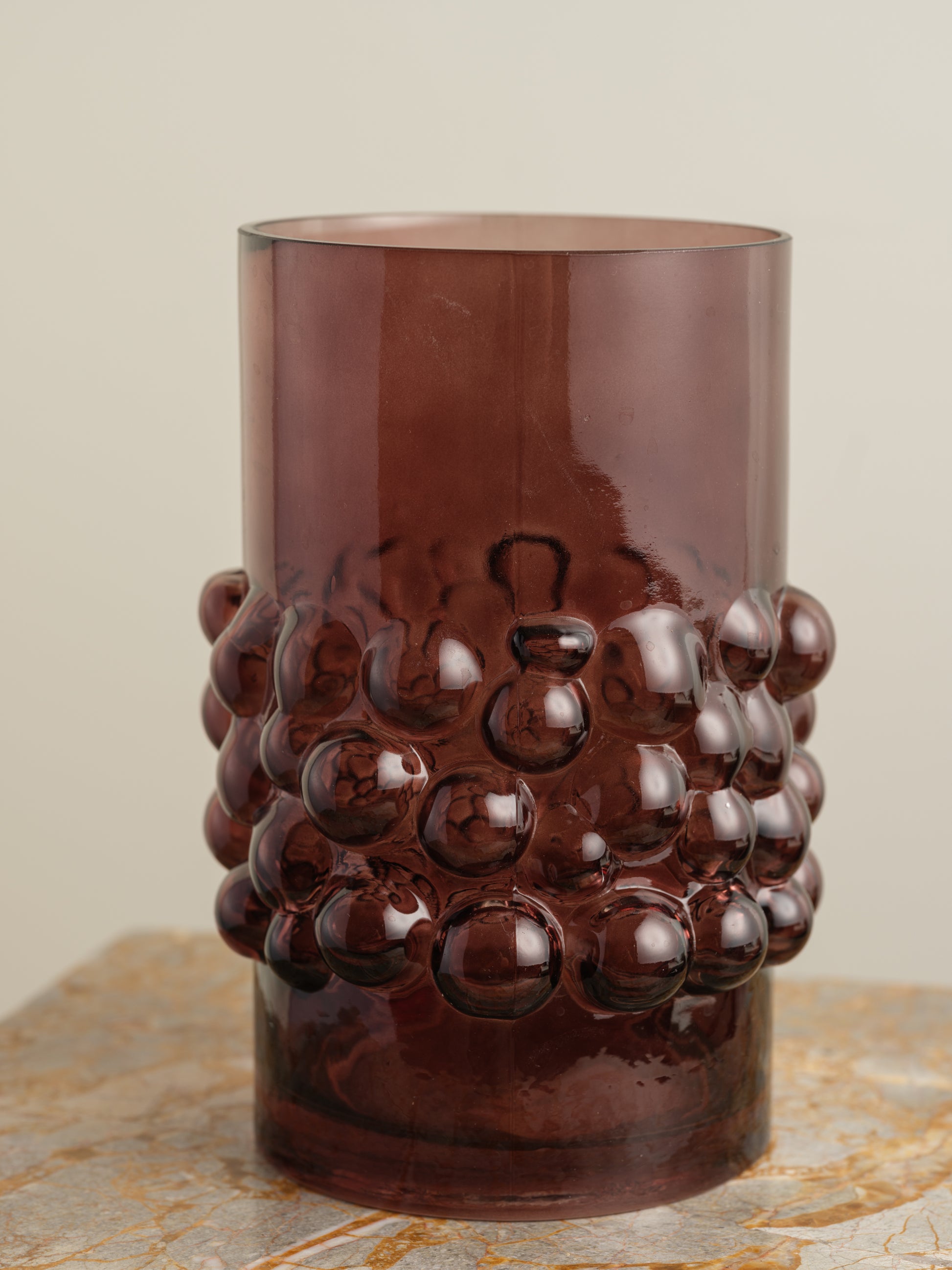 Deep plum-coloured glass vase with cylindrical form and raised hobnail texture around the middle.
