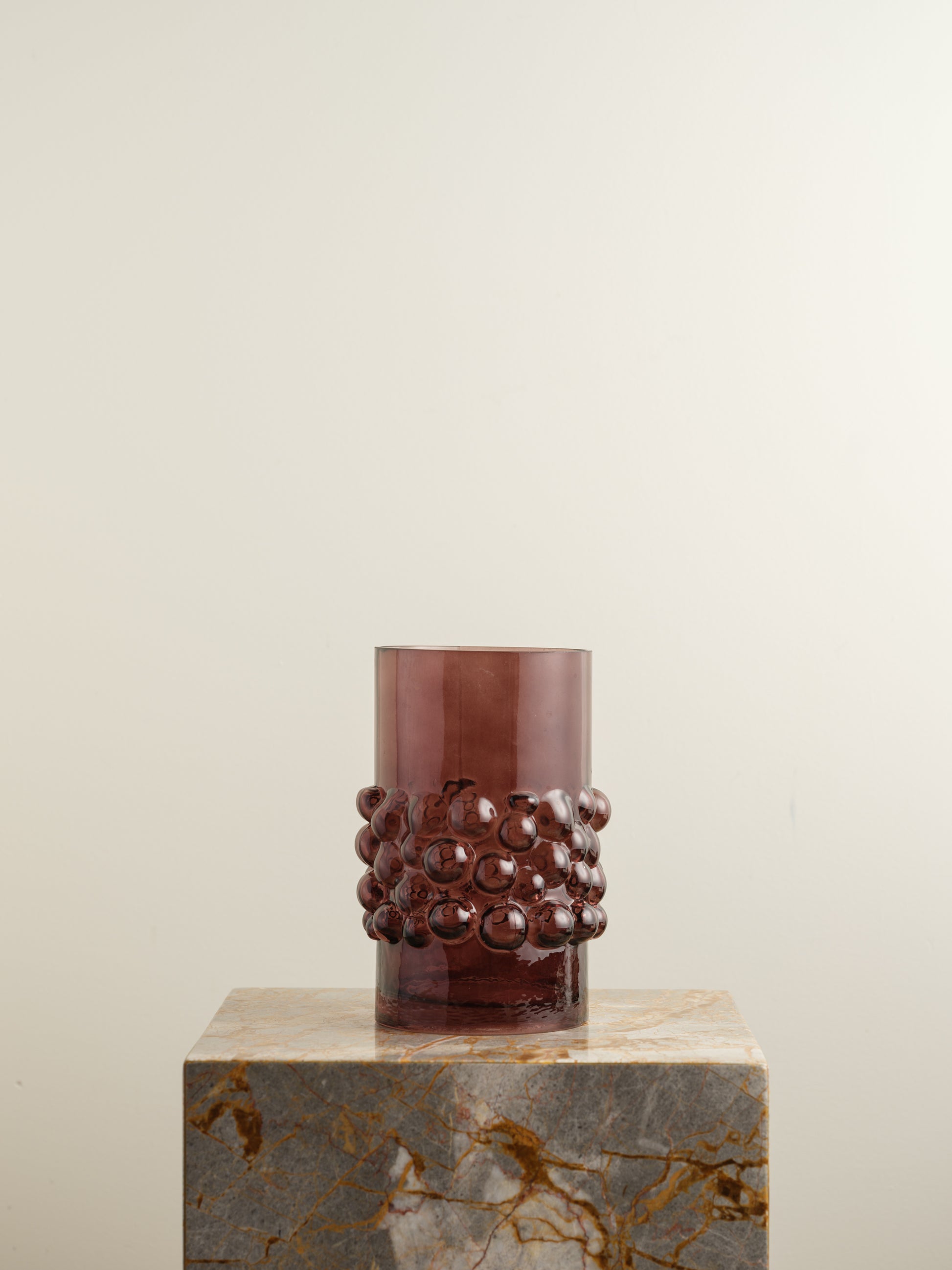 Deep plum-coloured glass vase with cylindrical form and raised hobnail texture around the middle.
