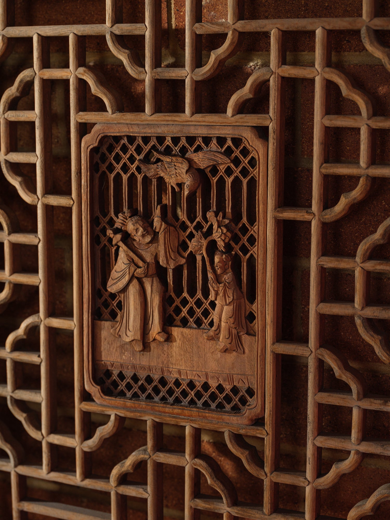Pair of antique Chinese lattice panels with intricate geometric fretwork and carved scholar scenes in relief at the center.
