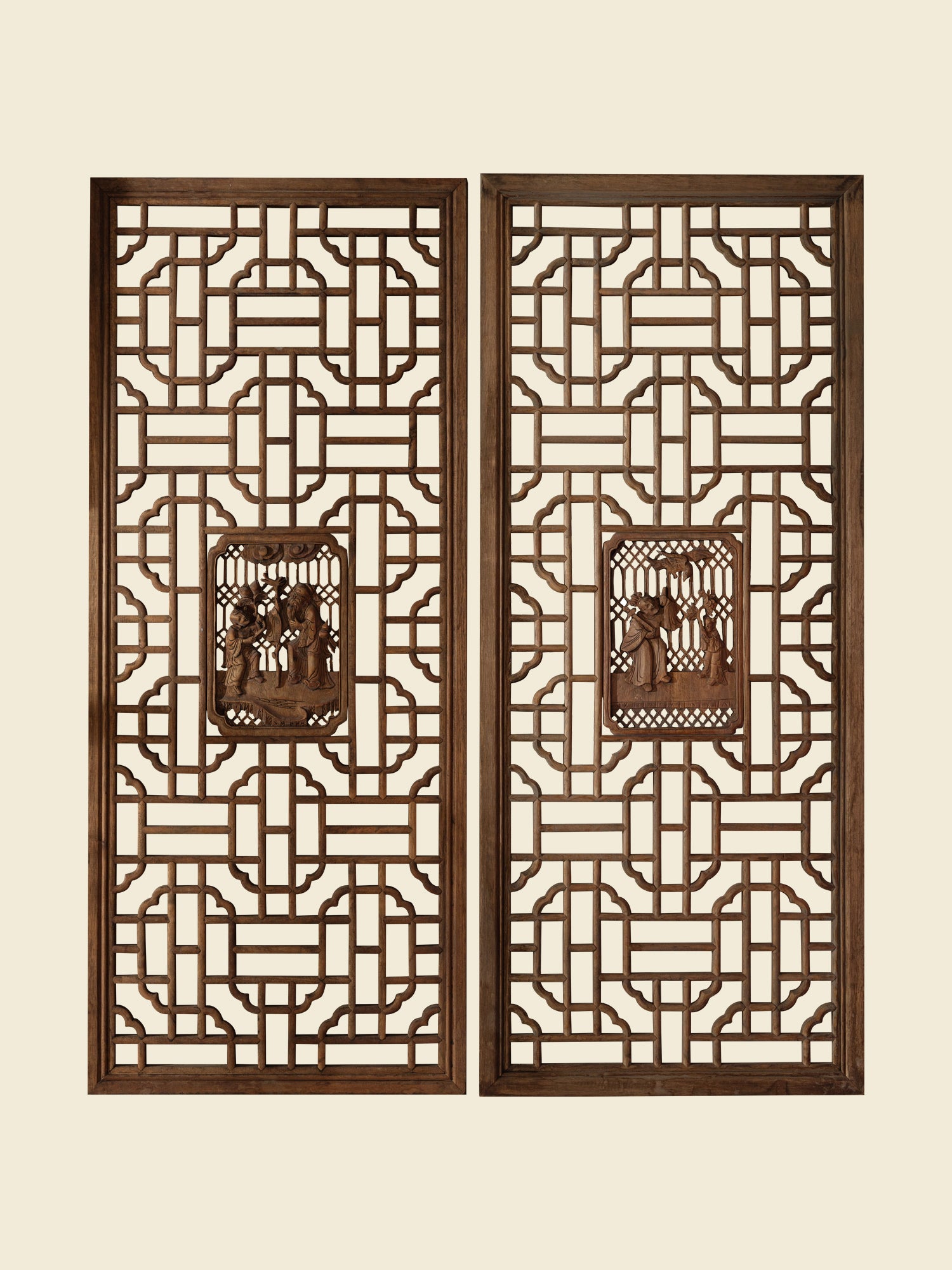 Pair of antique Chinese lattice panels with intricate geometric fretwork and carved scholar scenes in relief at the center.
