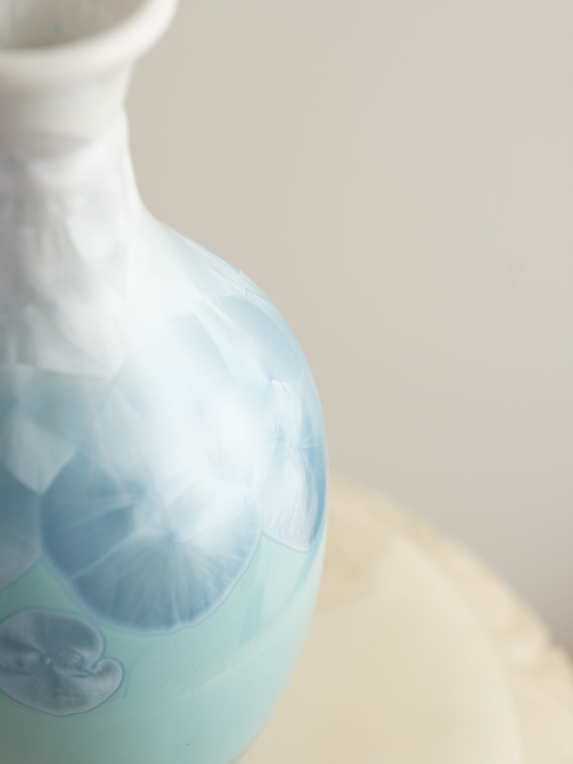 Porcelain vase in gradient white to aqua blue with crystalline bloom patterns on the surface.