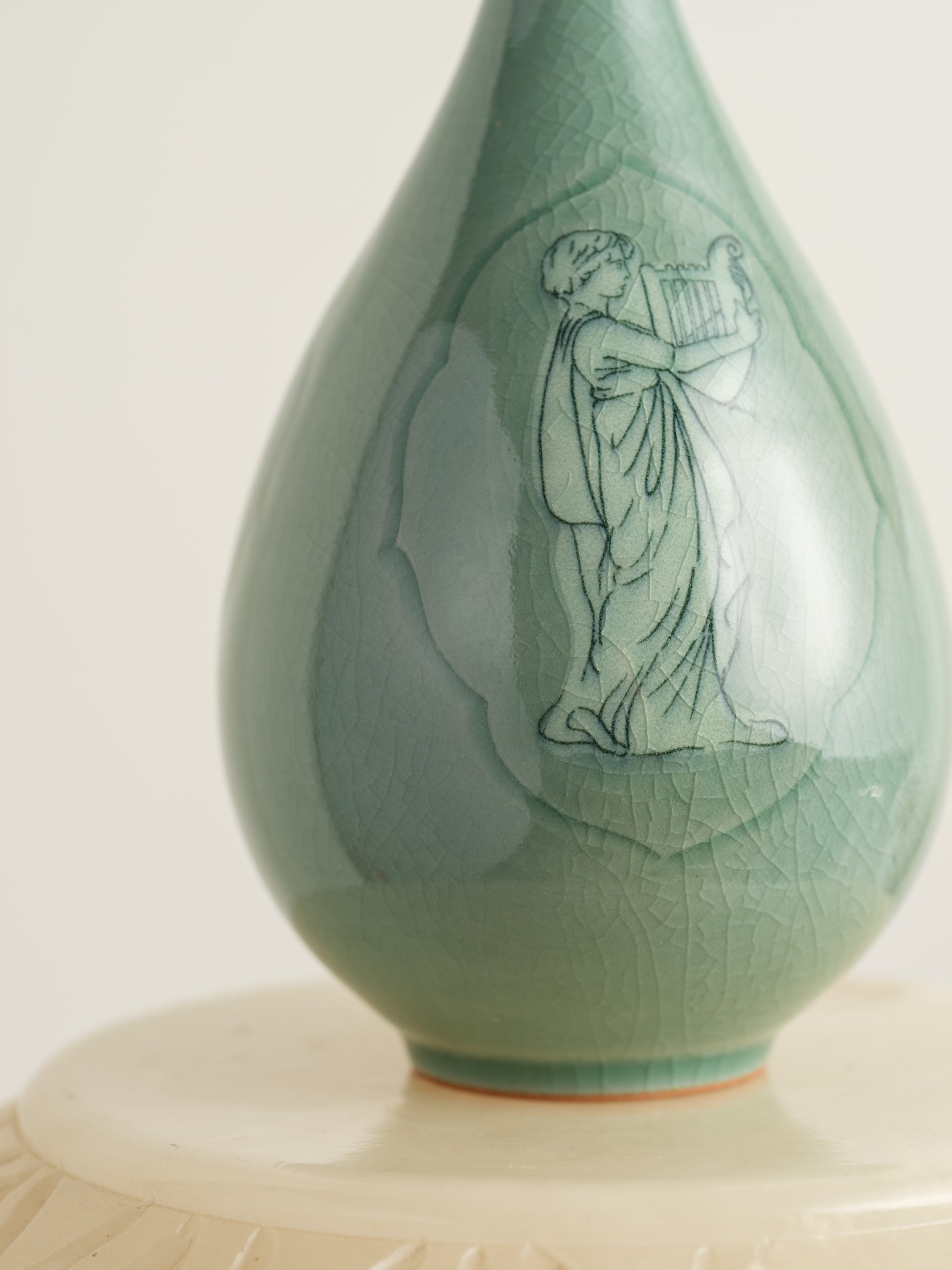 Song Whisper Celadon Vase, a delicate ceramic vessel with a slender flared neck and subtle engraved figure motif on a pale green glaze.