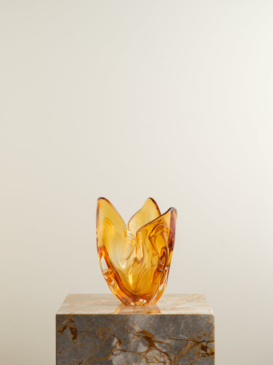Amber-orange art glass vase with petal-like sculptural form and fluid edges.