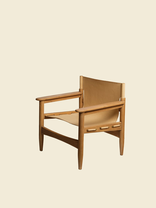Tanned leather armchair with natural wood frame, modern accent seating