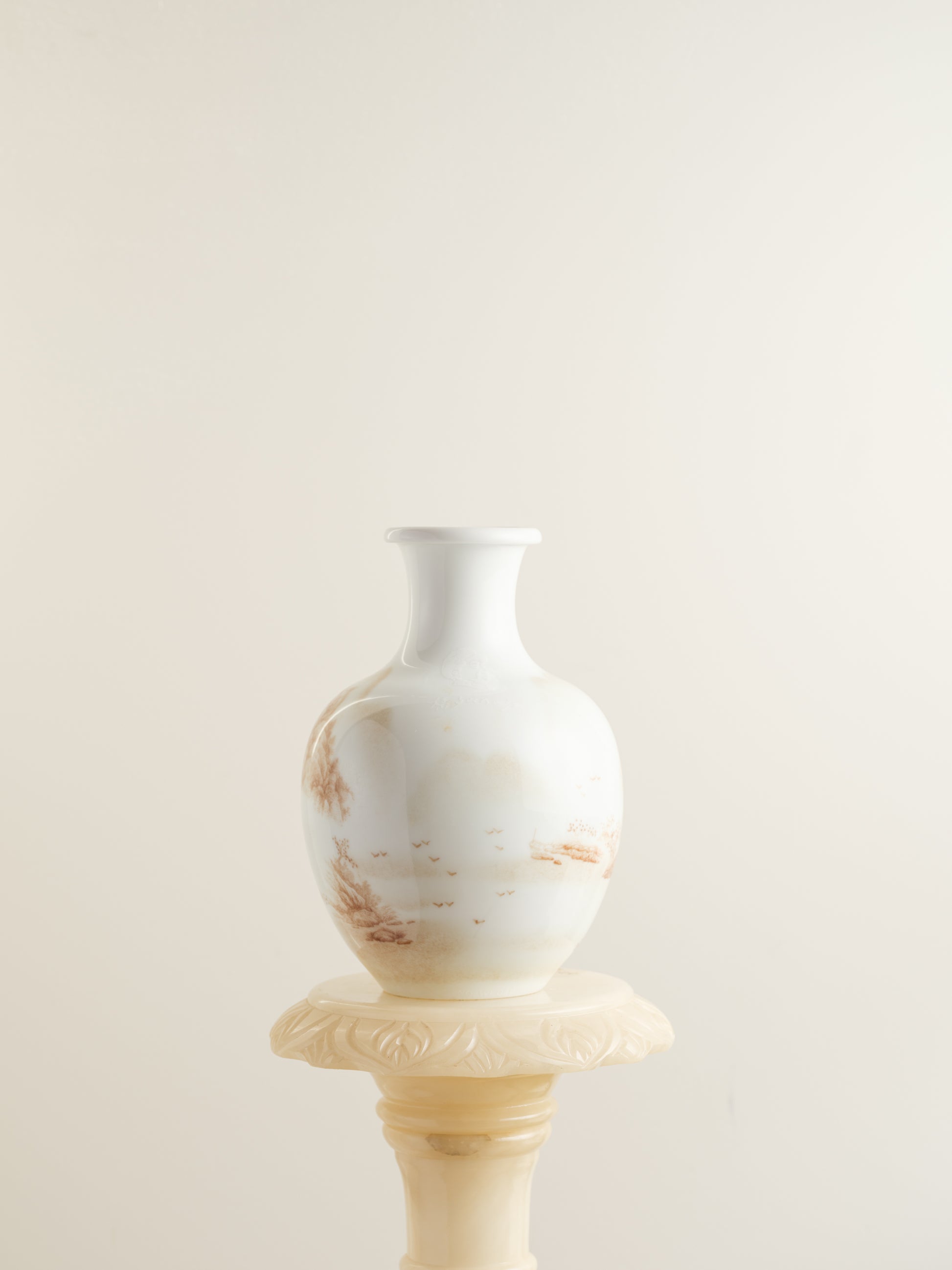 Porcelain vase with tea-wash glaze and hand-painted sepia landscape scene of mountains and flying birds.