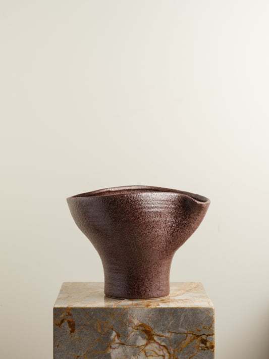 Hand-thrown brown stoneware vase with textured matte glaze and flared crest rim.
