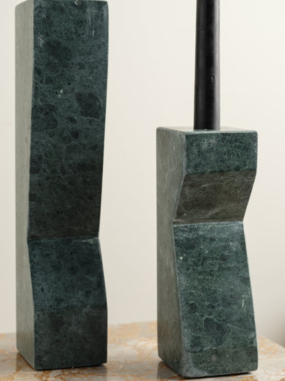 Pair of green marble candle holders with tall rectangular columns and black taper candles.