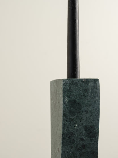 Pair of green marble candle holders with tall rectangular columns and black taper candles.