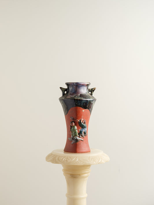 Vermilion Storyteller Relief Vase featuring hand-applied figurative relief on a tall form with dark glaze accents.