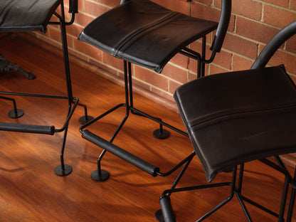 Black office chairs on a wooden floor with a brick wall background