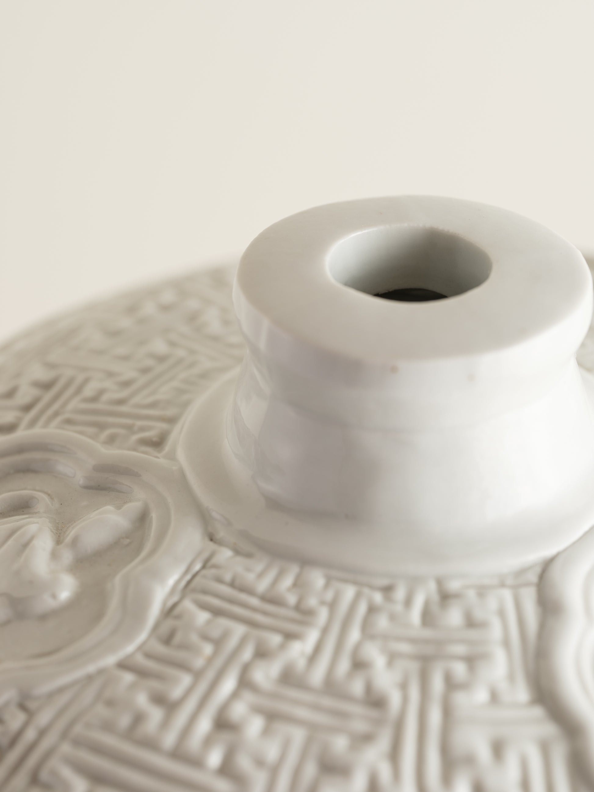 White porcelain meiping vase featuring intricate dragon relief motifs and geometric borders.