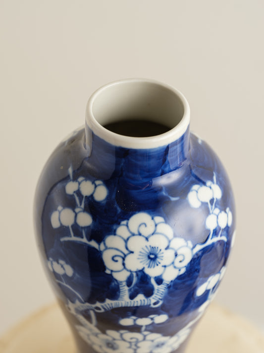 Porcelain vase in deep indigo glaze featuring hand-painted white plum blossoms.

