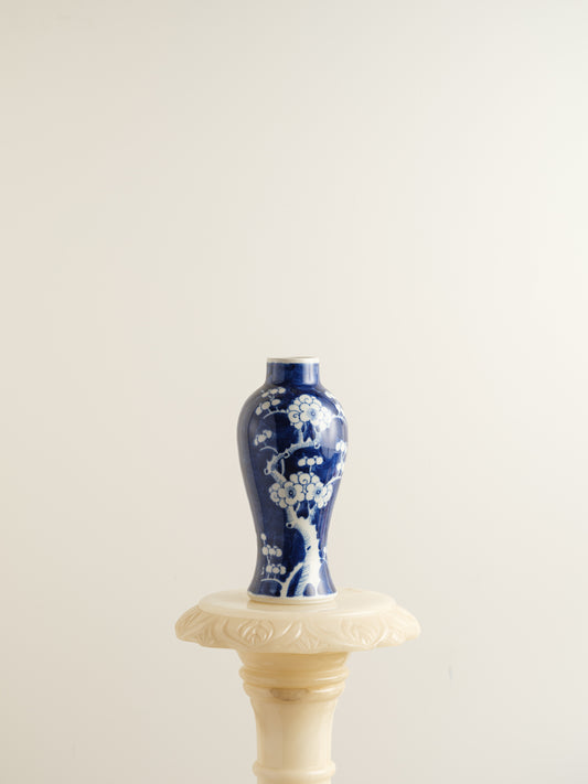 Porcelain vase in deep indigo glaze featuring hand-painted white plum blossoms.
