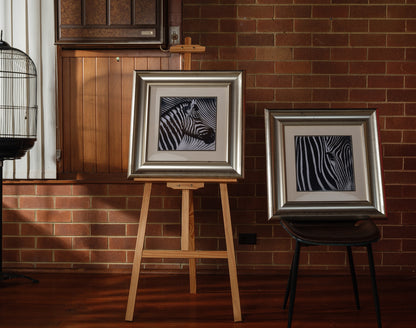 Fine art prints titled Zebra Pair, featuring two framed black and white zebra portraits with bold stripes, sold together as a pair.